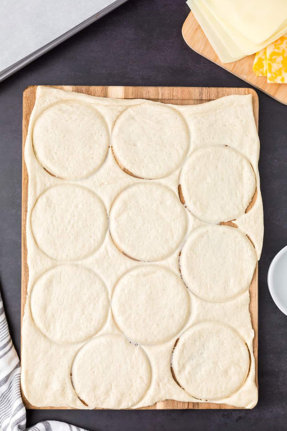 Cutting pizza dough into circles that are about two inches across.