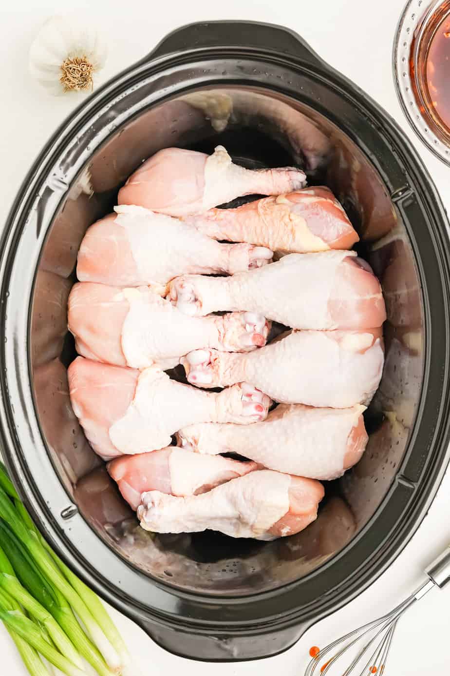 Drumsticks lined up in a slowcooker from overhead.