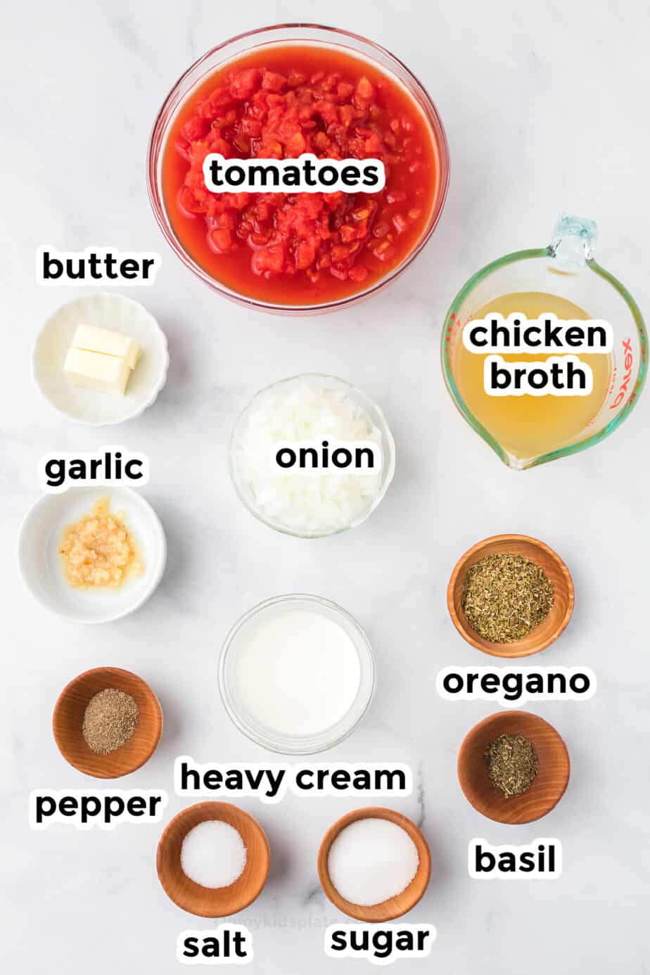 Ingredients for tomato soup in bowls from overhead with labels.