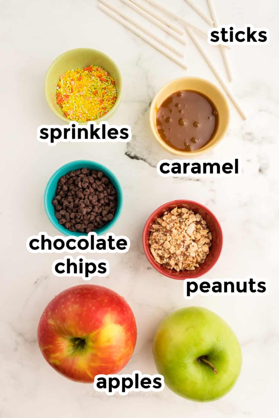 Carmel apple slice ingredients in bowls on a counter from overhead with labels.