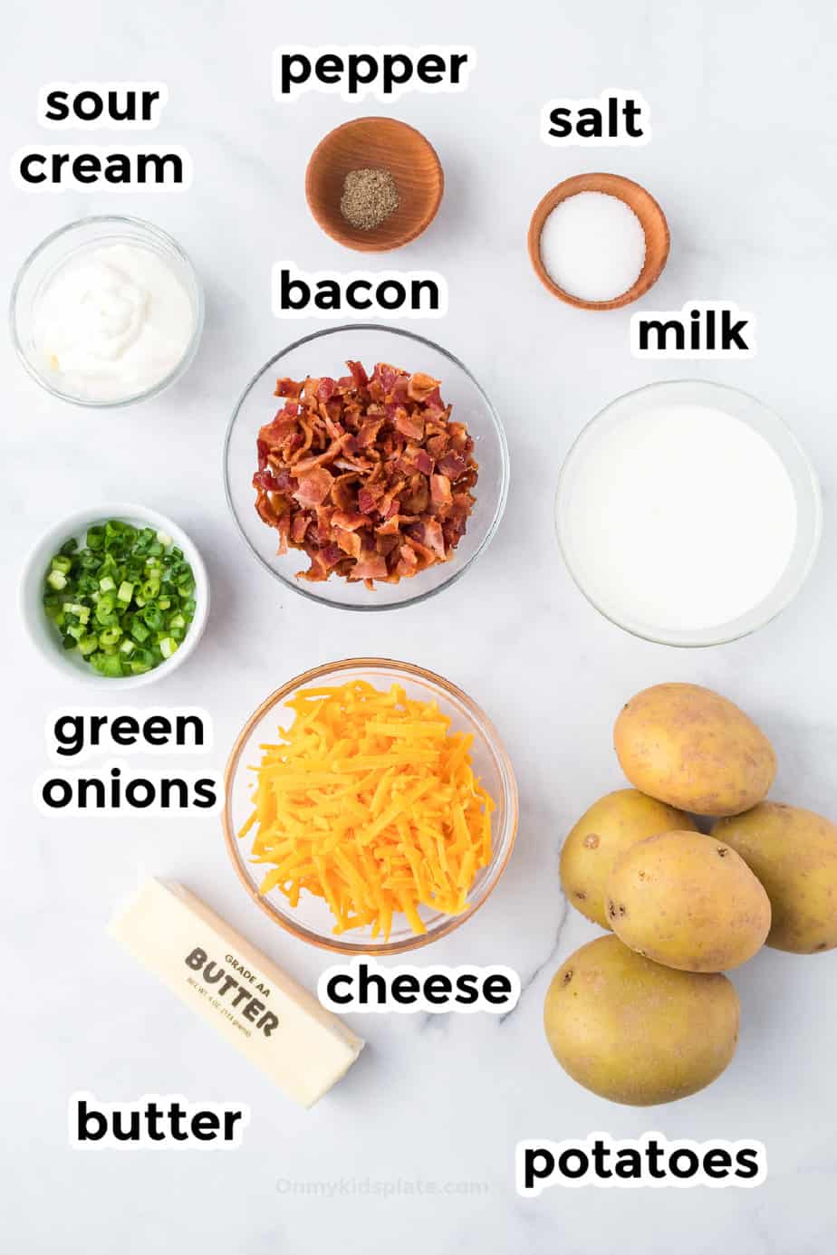 Ingredients for loaded mashed potato casserole from above on a counter with text labels.