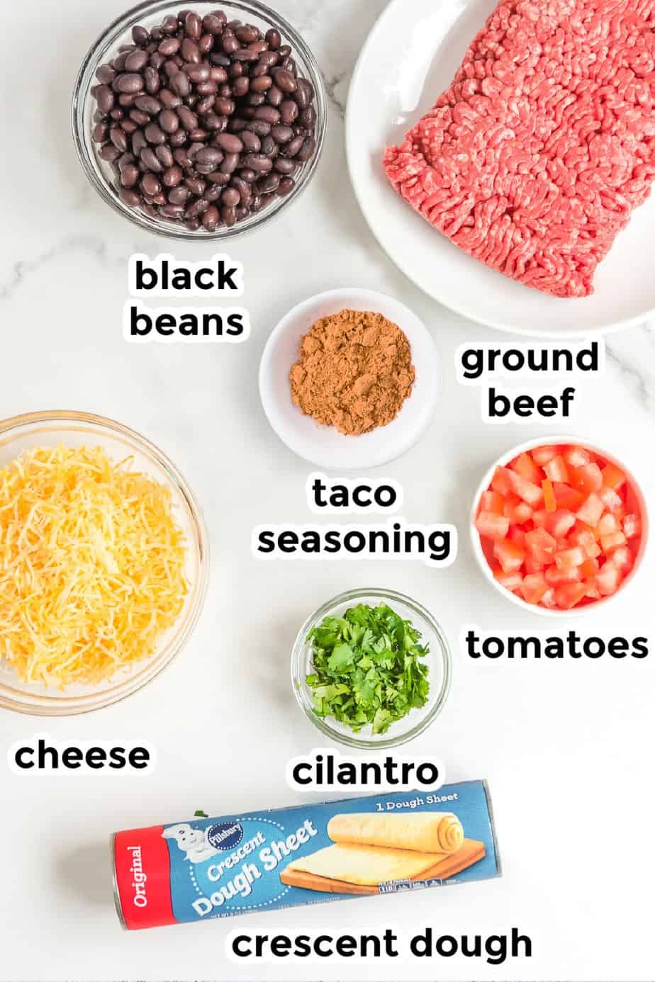 Ingredients for baked taco cups in bowls on a counter from overhead with labels