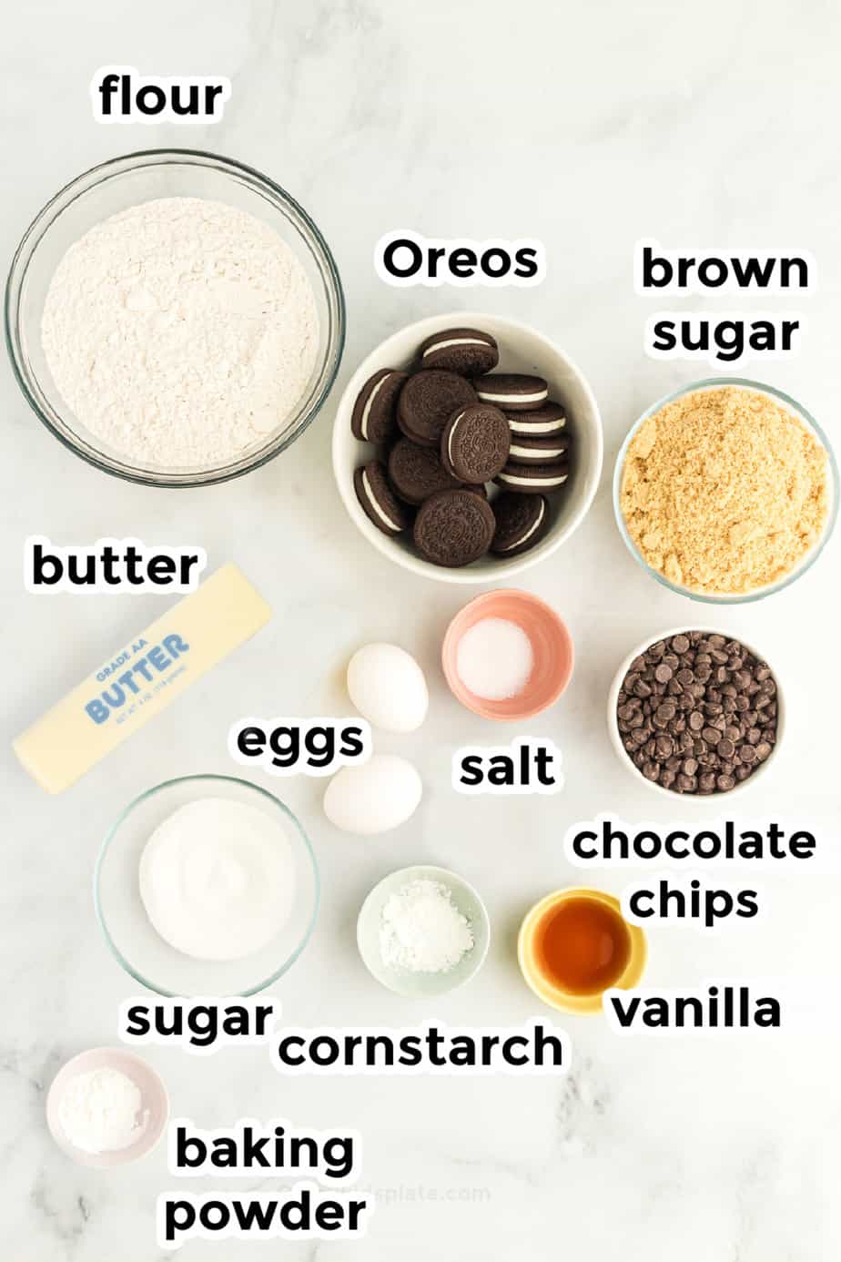 Ingredients for oreo stuffed chocolate chip cookies in bowls on a counter from overhead with text labels.