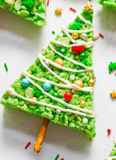 Close up zoom view of a green triangle rice krispie treat decorated like a Christmas tree on a counter..
