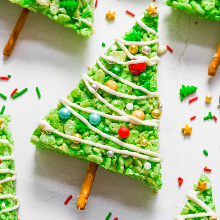 Close up zoom view of a green triangle rice krispie treat decorated like a Christmas tree on a counter..