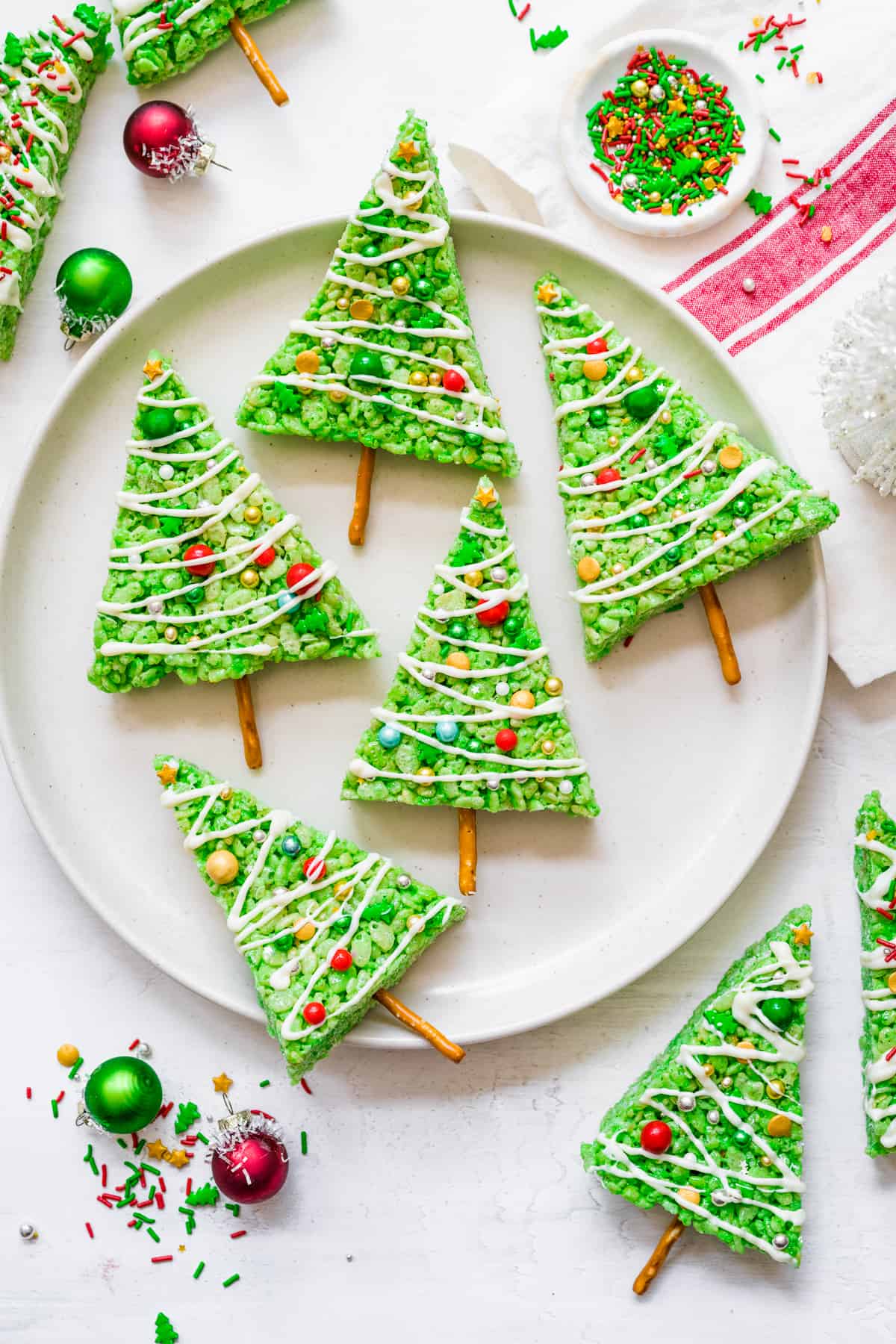 Green Rice Krispie treats decorated like Christmas trees on a plate from overhead.
