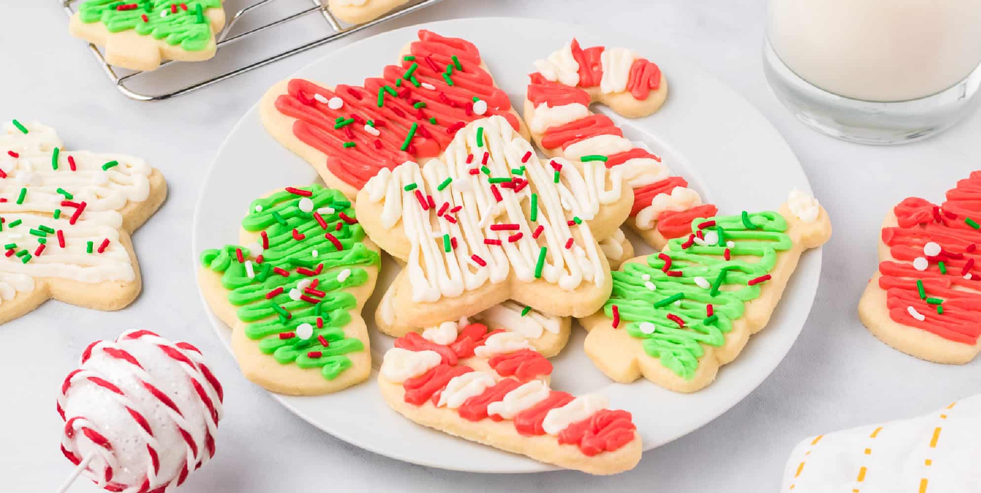 Cutout frosted Christmas sugar cookies on a plate.