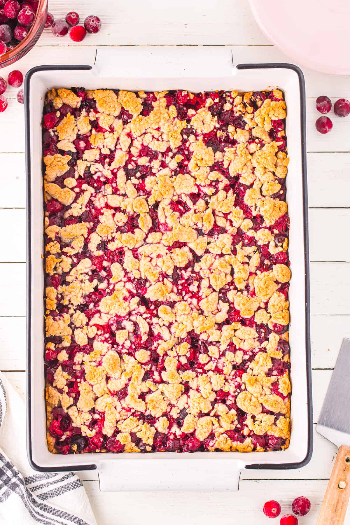 Slightly brown cranberry crumble bars baked in a pan from overhead on a counter.