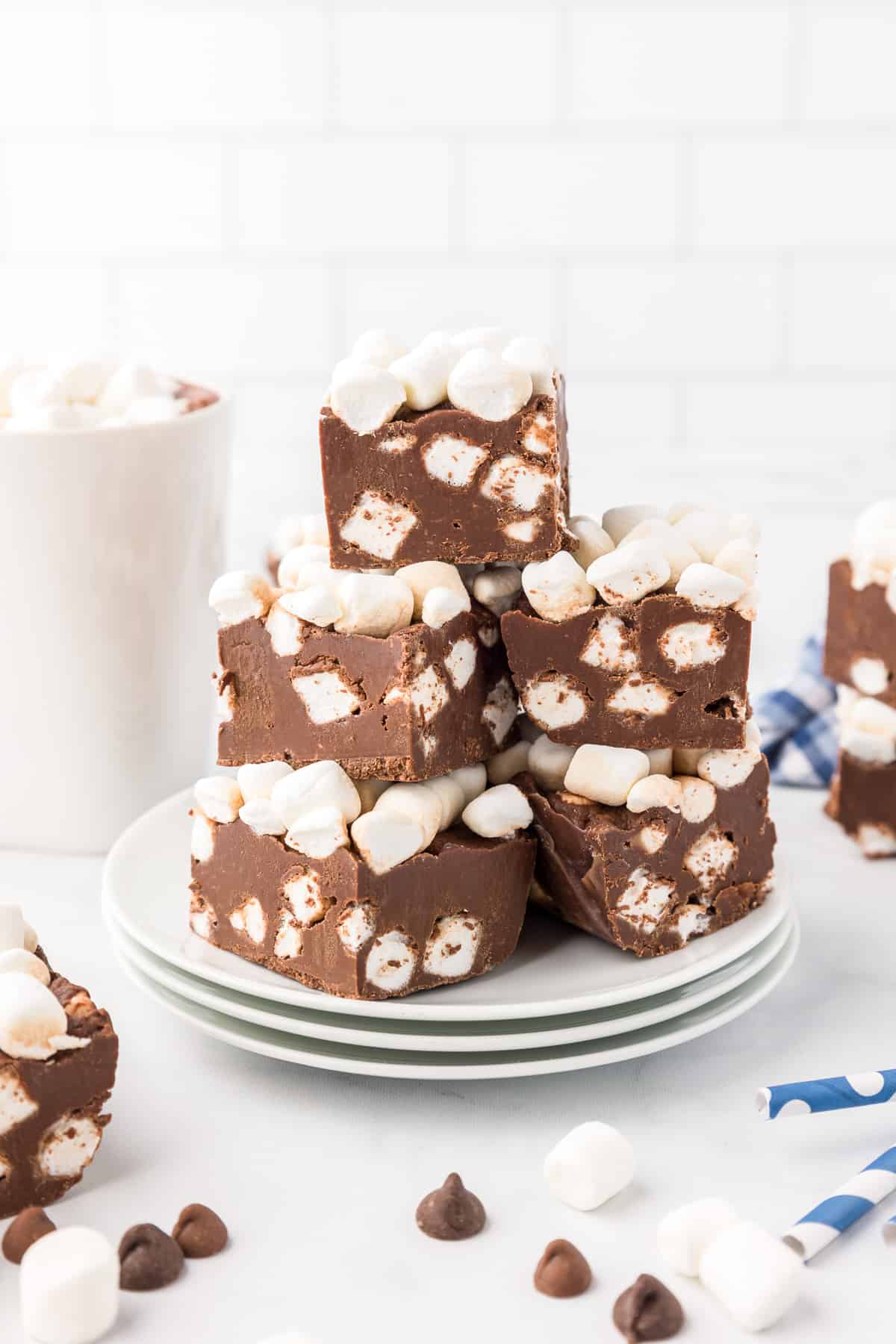 Hot chocolate fudge squares stacked high on a plate from the side.