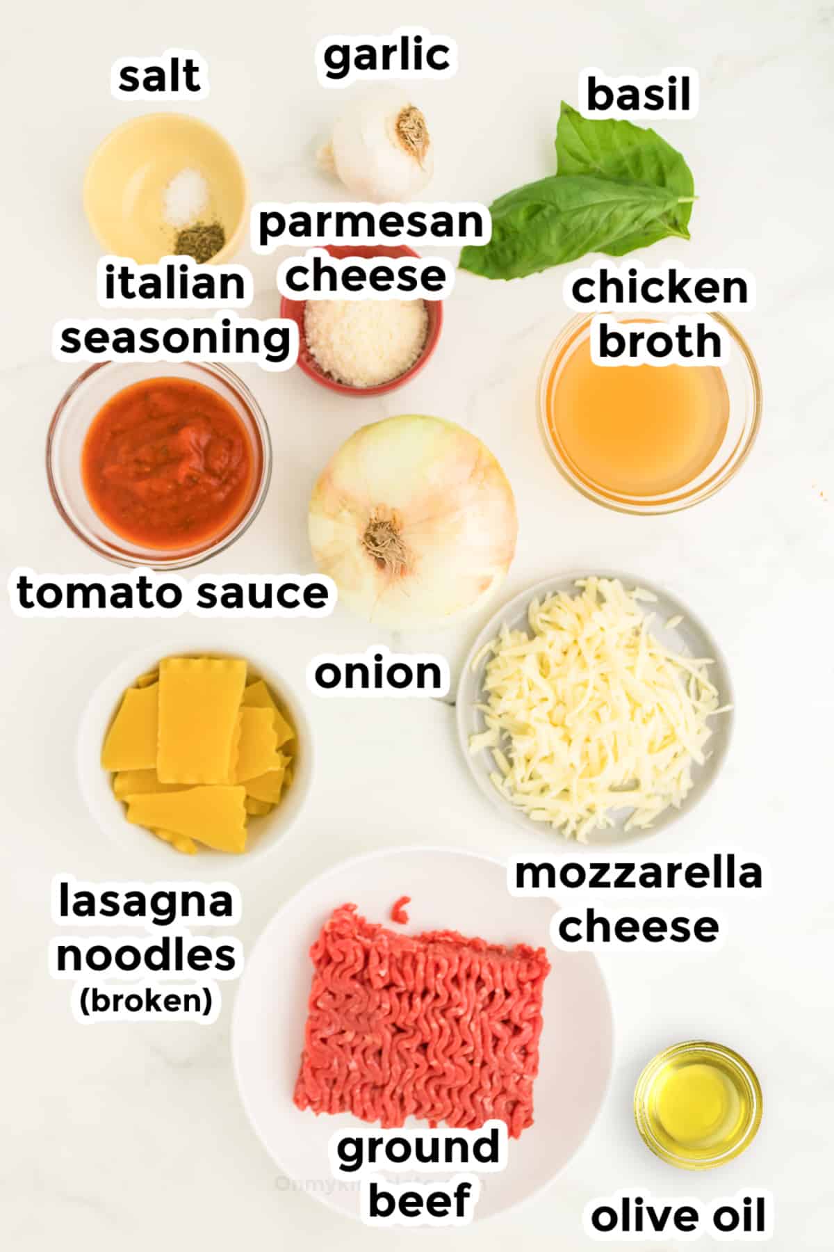Ingredients for lasagna soup in bowls on a counter from overhead with text labels.