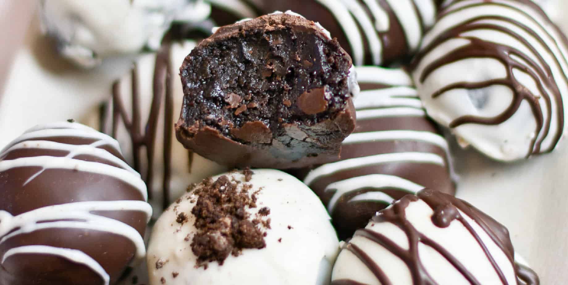 Wide vie of stacked oreo ball truffles with one missing a bite.