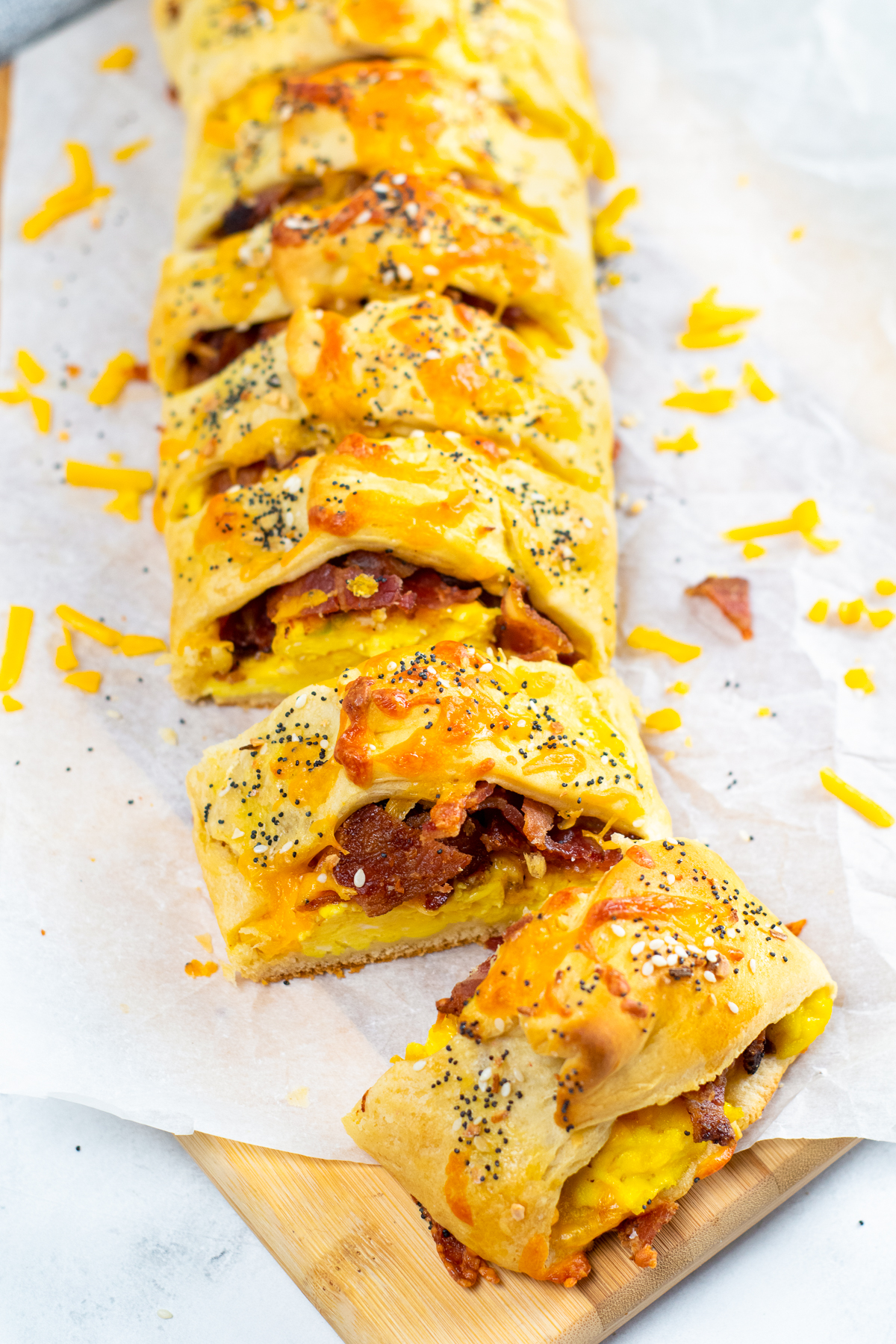 Breakfast crescent roll braid baked and sliced on parchment paper.