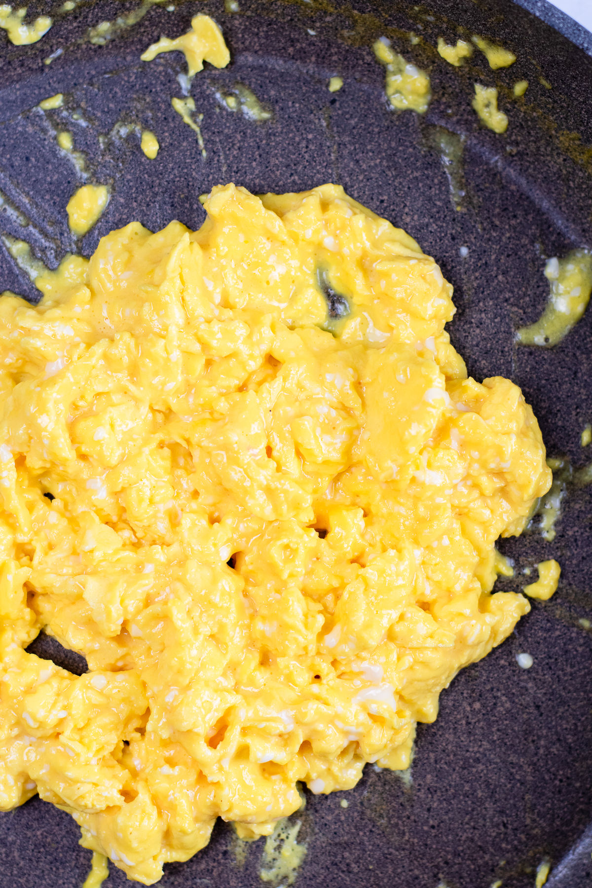 Soft scrambled eggs close up in a pan.