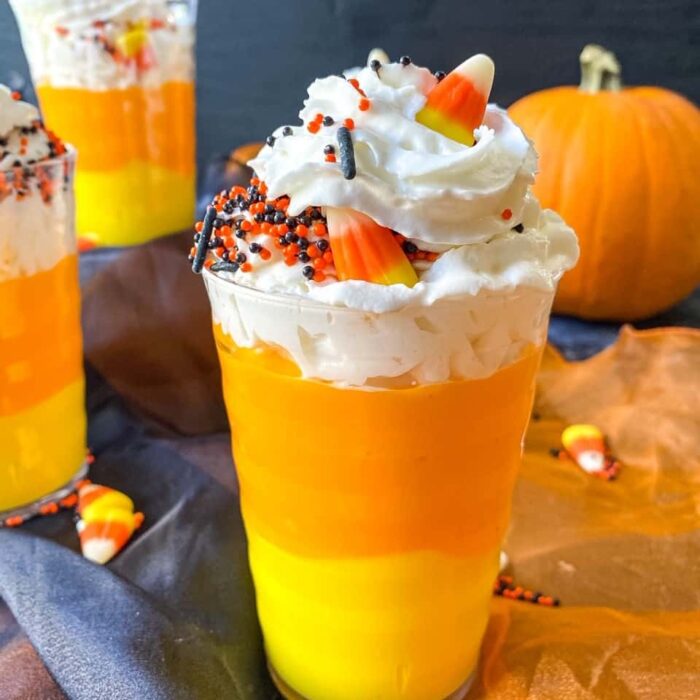 Orange and yellow pudding layered with whipped cream to look like a candy corn in a cup.