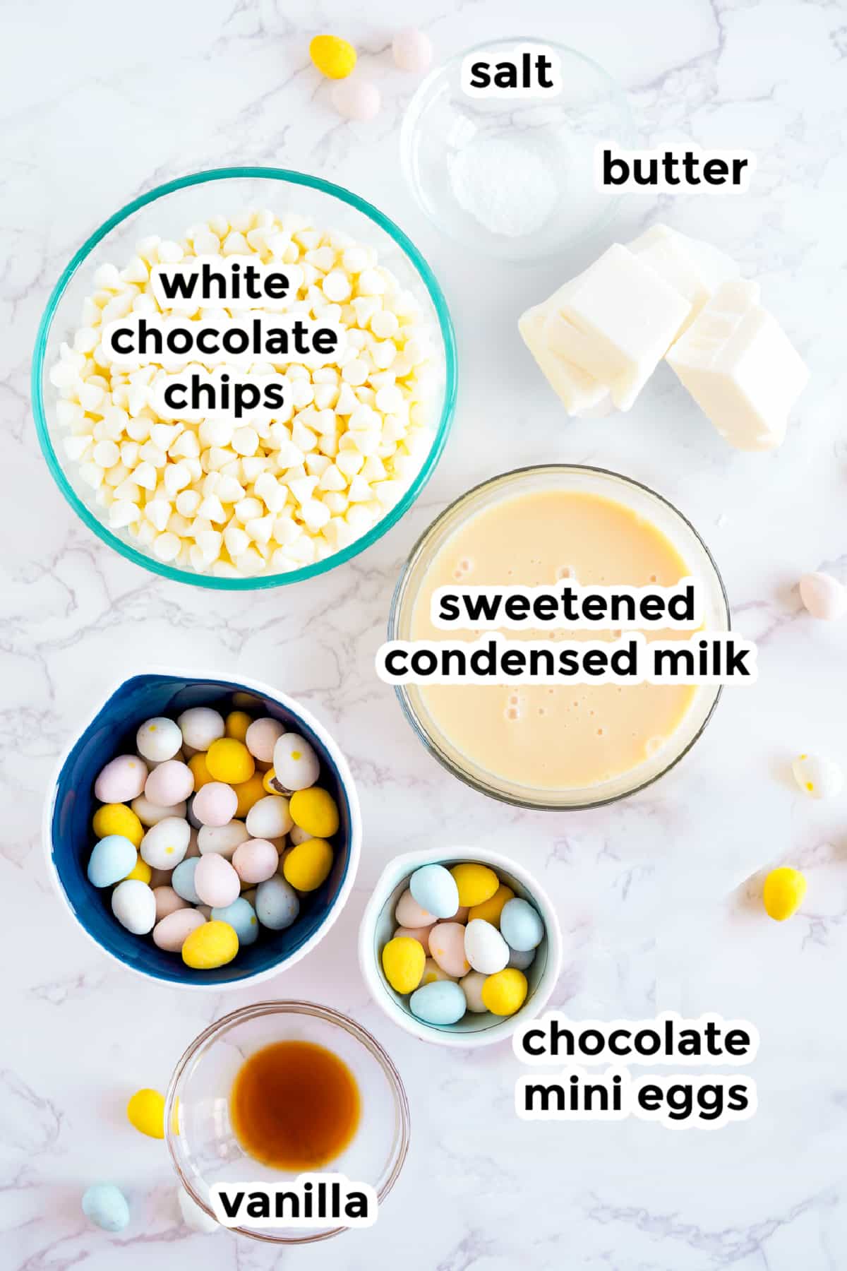 Ingredients for Easter fudge on a counter in bowls with text labels.