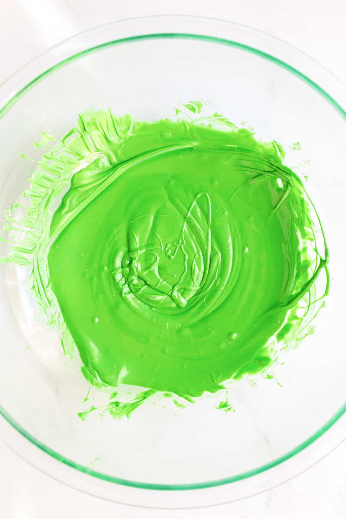 Melted green chocolate in a large bowl from above.