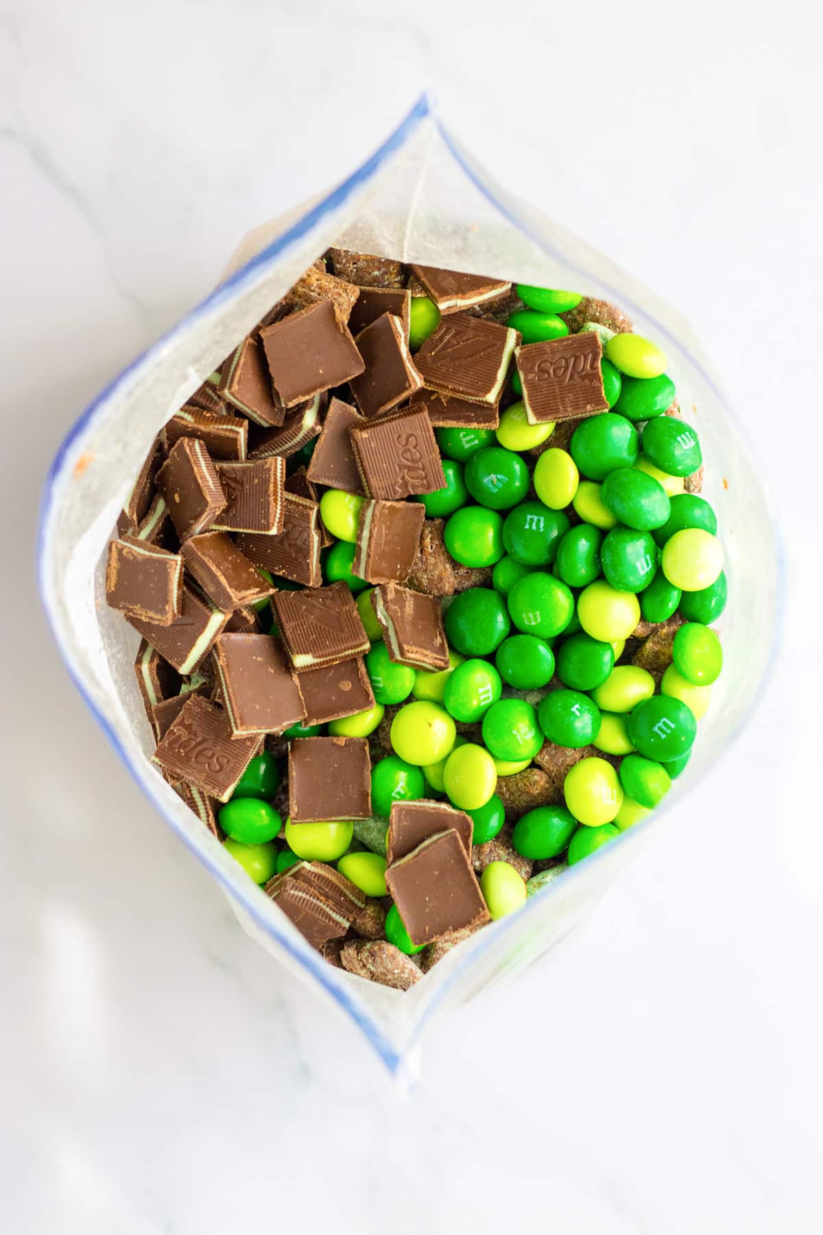 Andes mint pieces and mint M&Ms in a large zip top bag from above.
