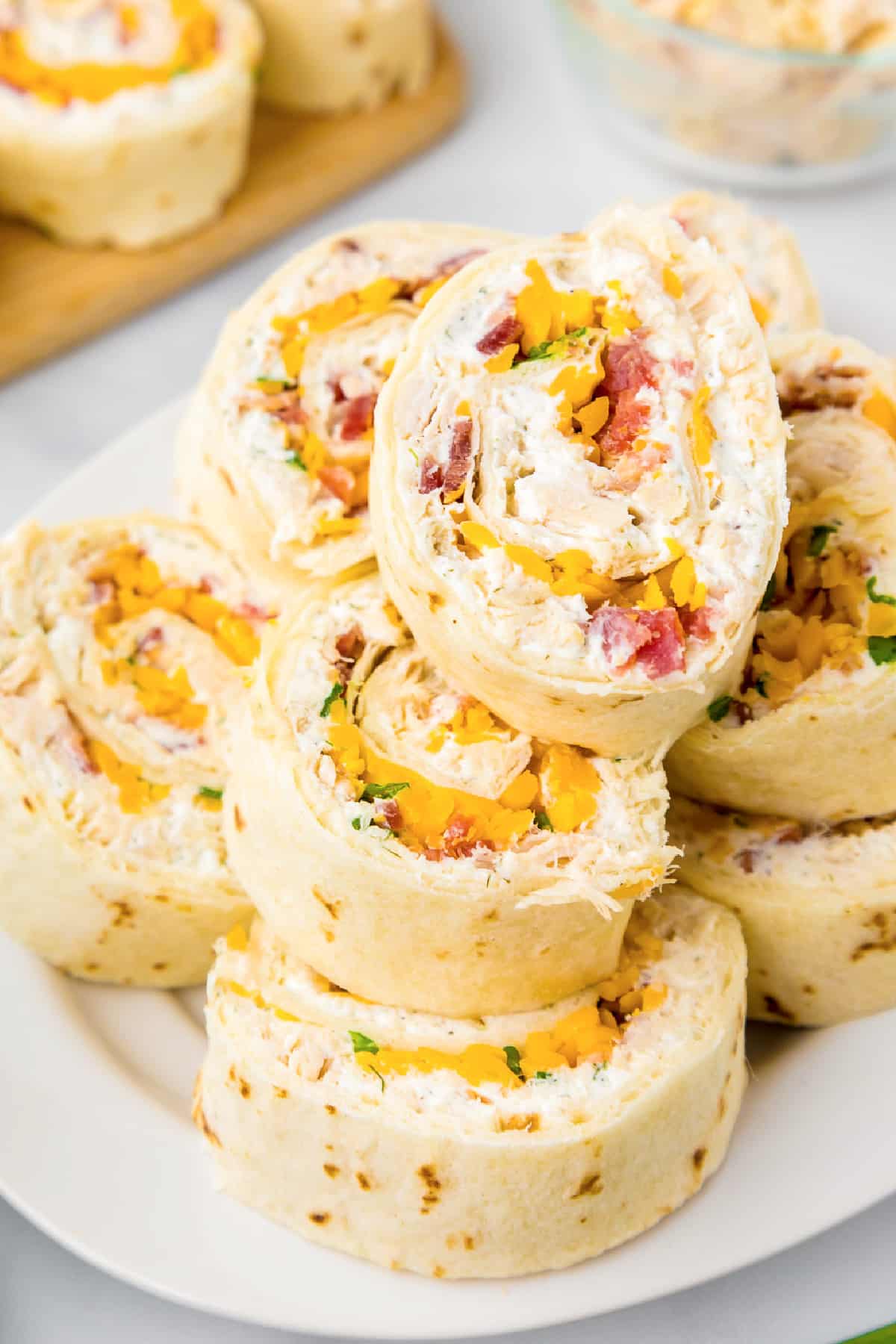 Close up vie of stacked chicken bacon ranch pinwheels on a platter from overhead.
