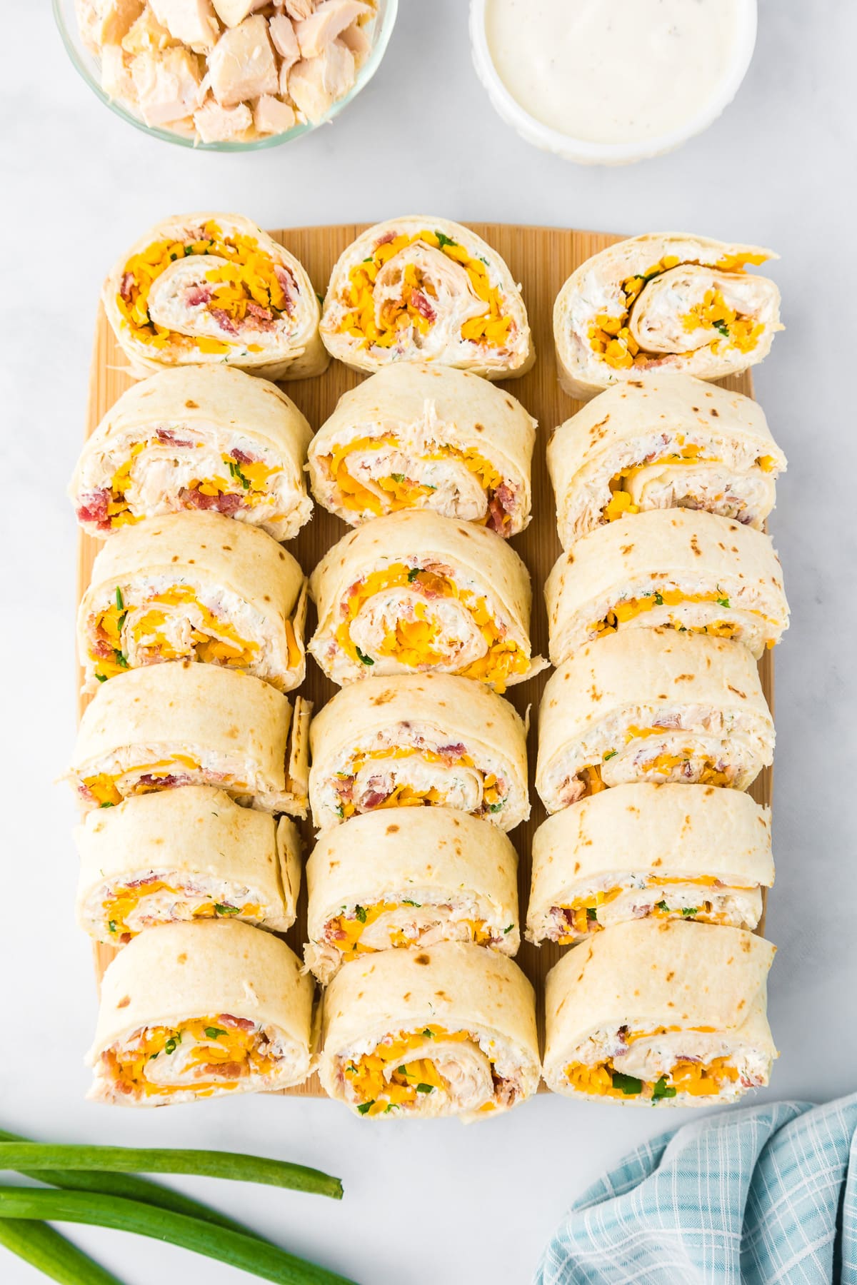 Sliced chicken bacon ranch pinwheels in rows on a cutting board from overhead.