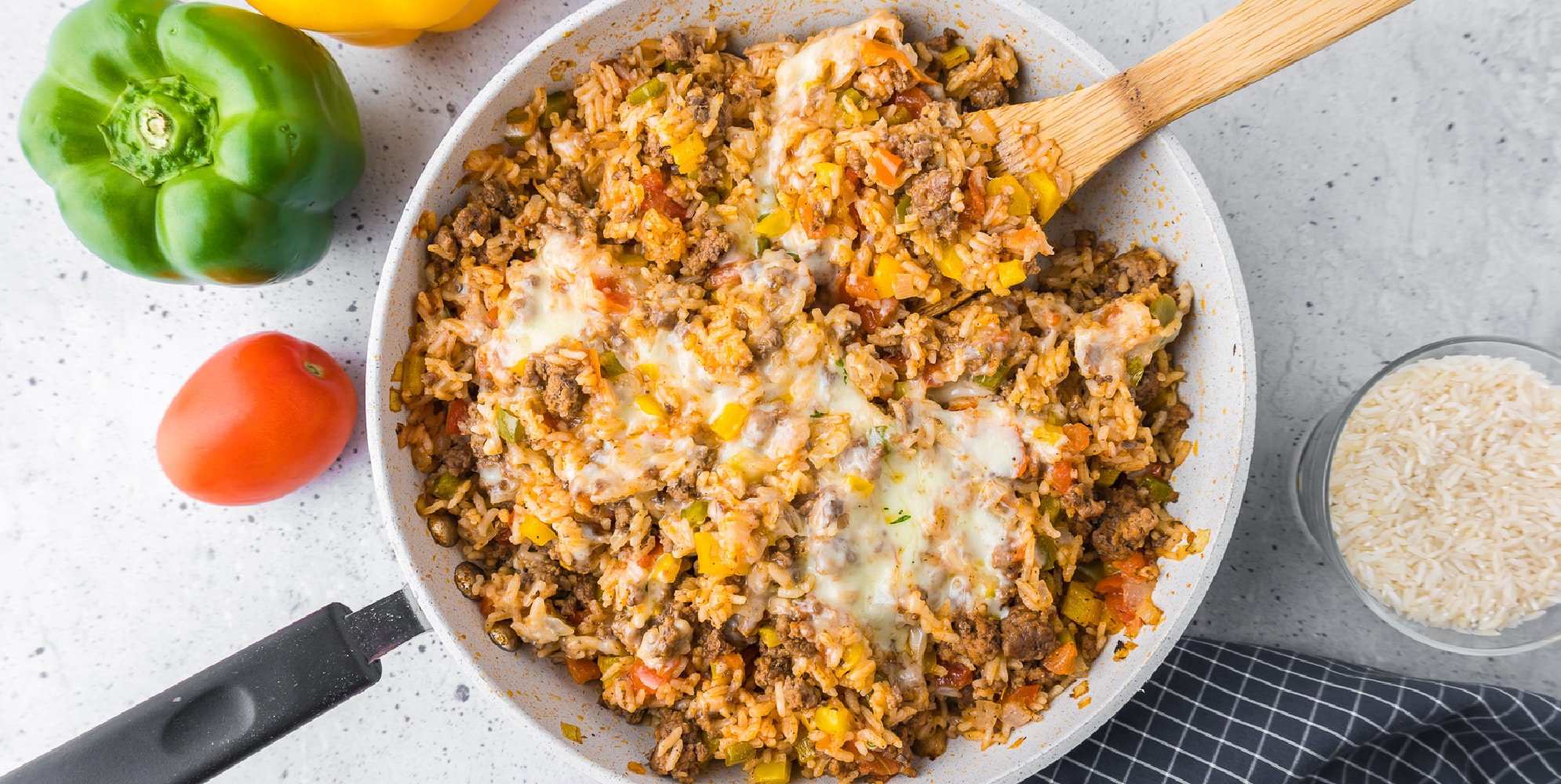 wide view of a rice skillet topped with cheese and mixed with diced bell pepper.