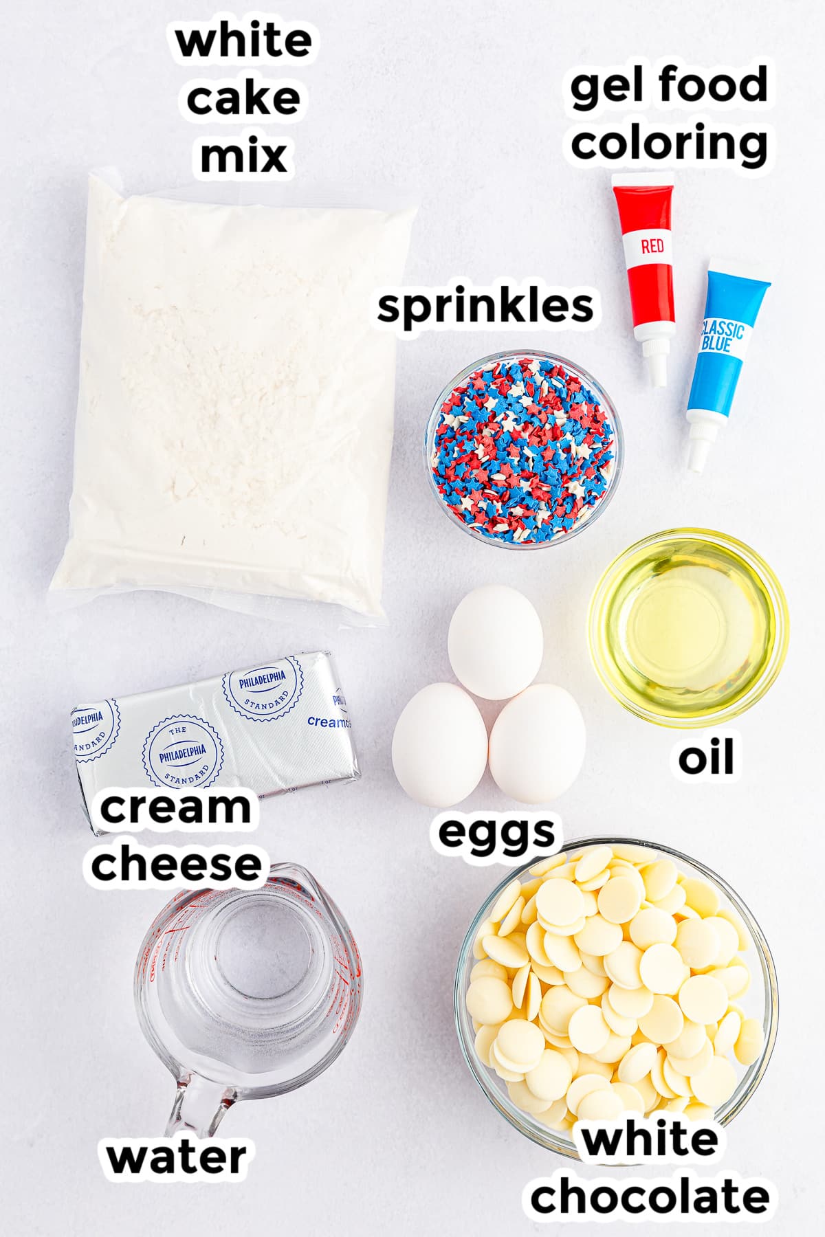 Ingredients for 4th of july cake balls on a counter in bowls from overhead with text labels.