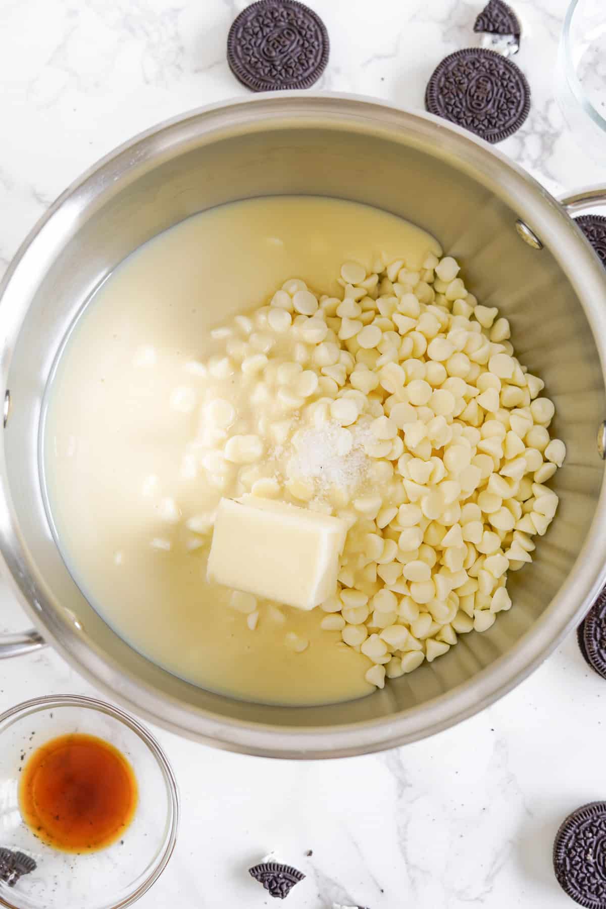 Butter, white chocolate chips and sweetened condensed milk in a large pan from above.