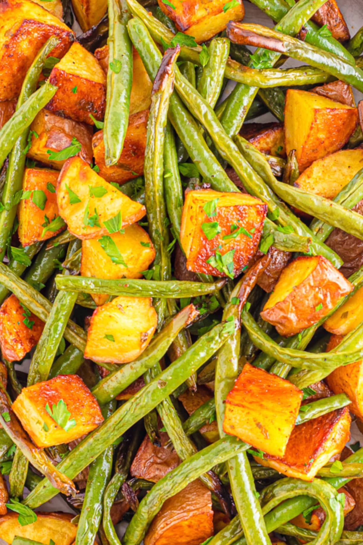 Close up of roasted potatoes mixed with green beans.