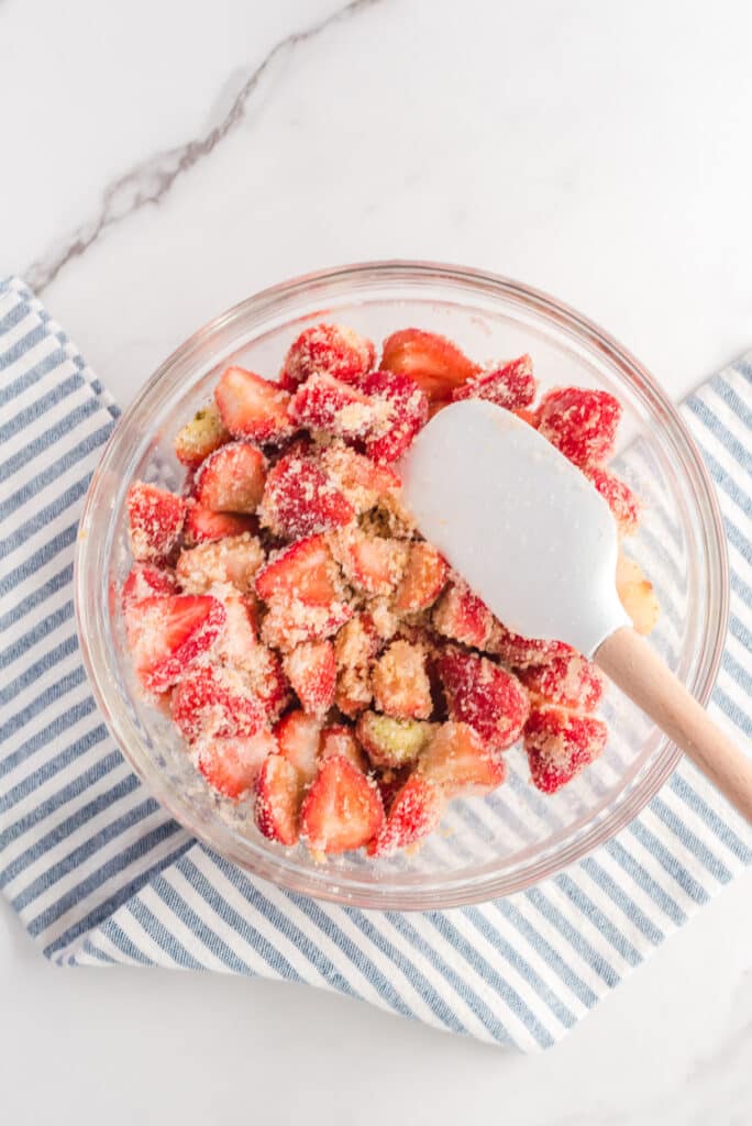 Sliced strawberries in a bowl mixed with brown sugar and white sugar from above.