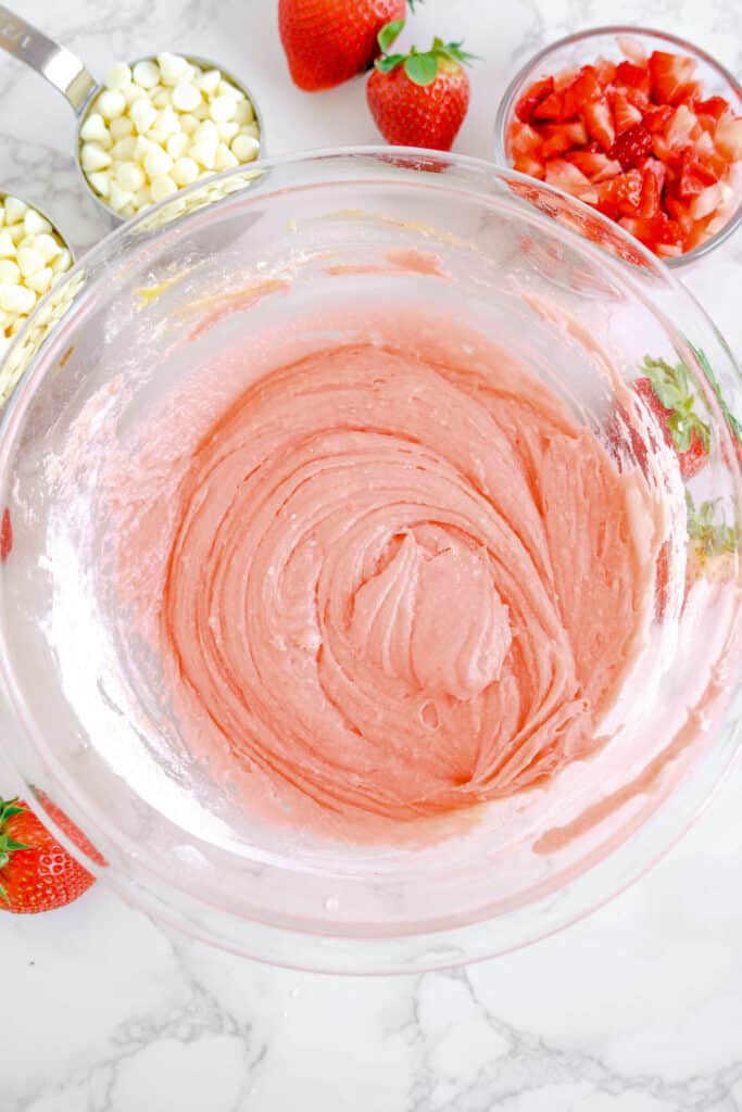 Pink strawberry cookie dough fully mixed in a large mixing bowl from overhead.