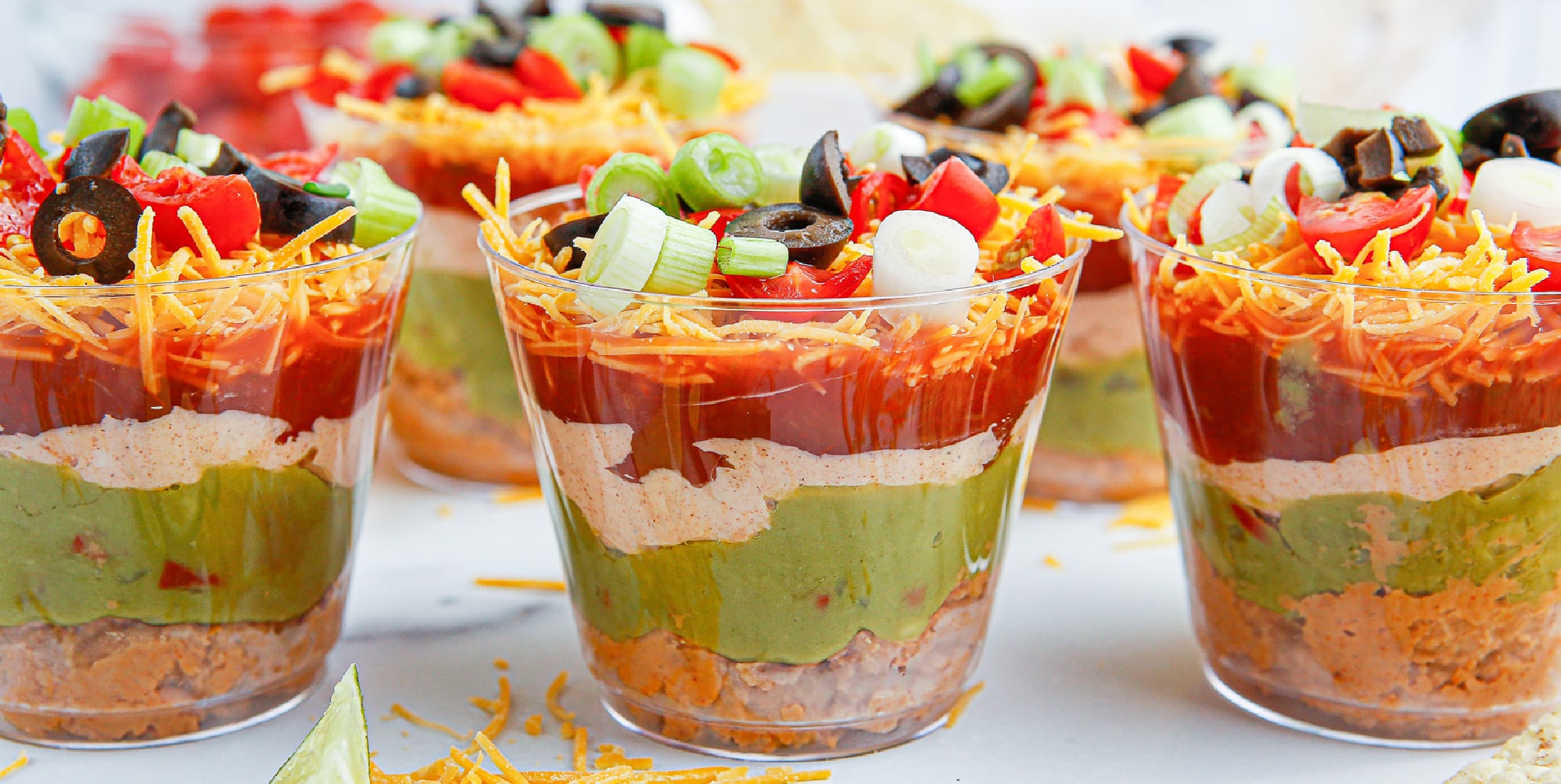 Wider view of three seven layer dip cups from the side to see the layers.