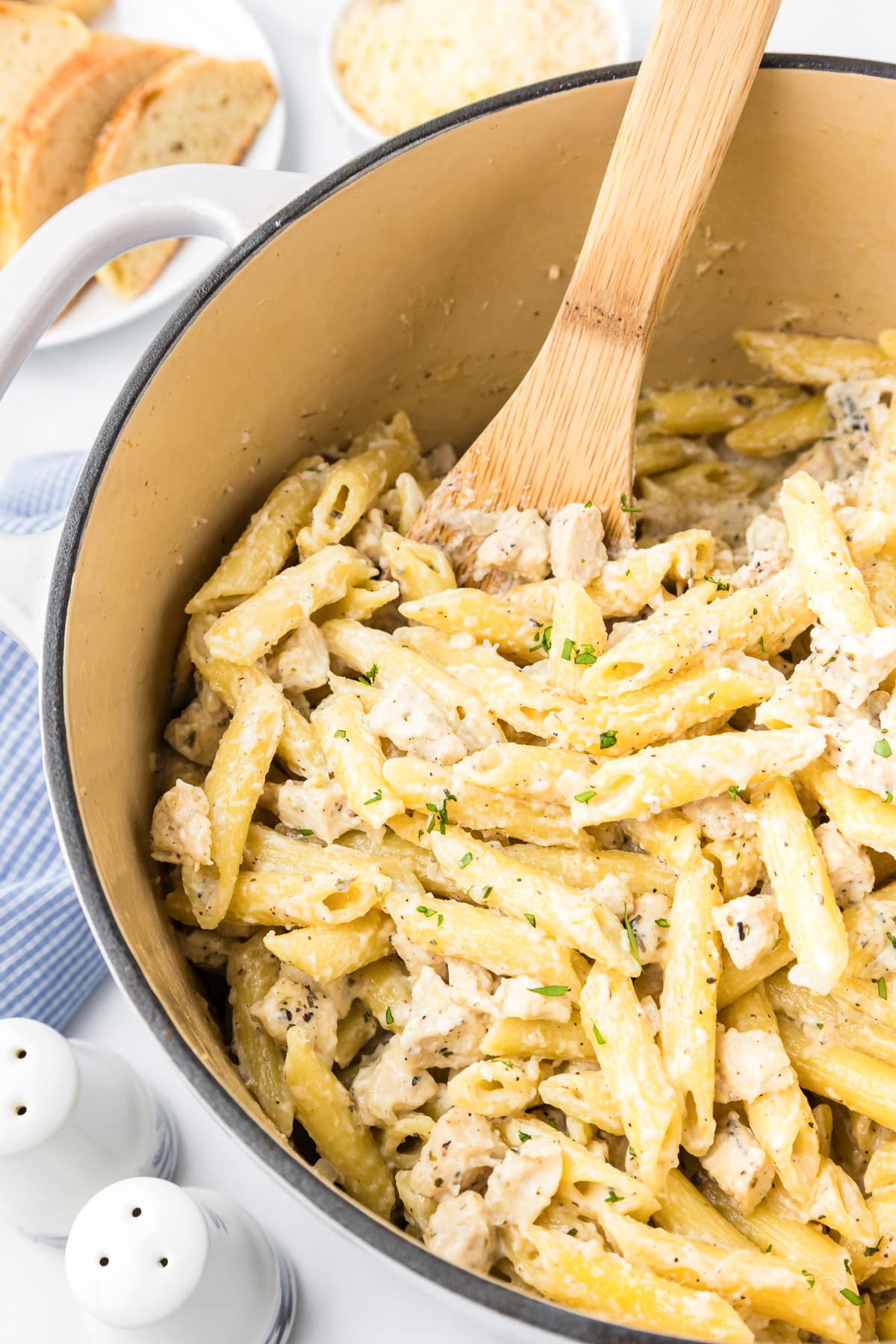 Chicken penne alfredo being scooped from a pot.