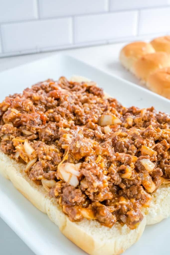 Open top Sloppy joe slider sandwiches on a white plate.