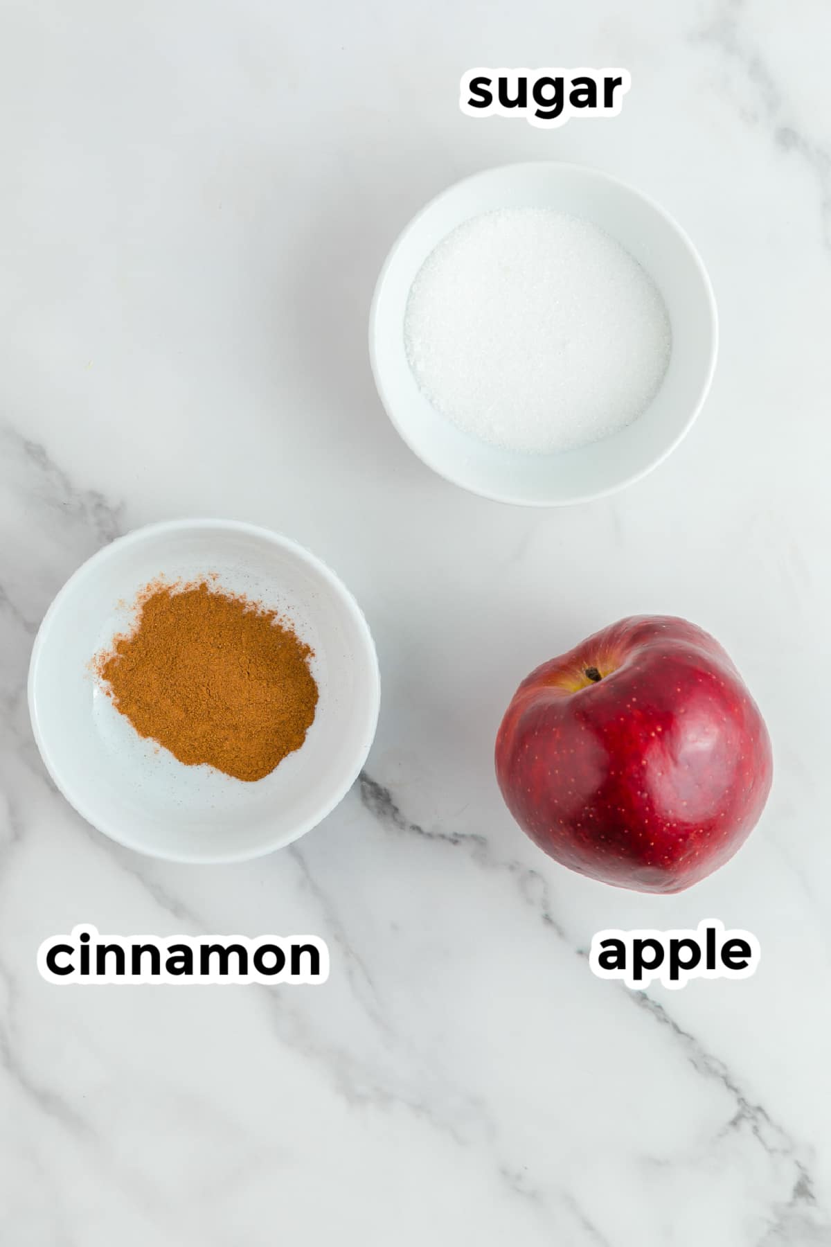 Ingredients for apple chips in bowls on a counter with text title labels from above.