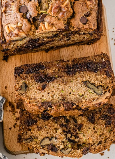 Square view of chocolate chip zucchini bread sliced on a cutting board from overhead.