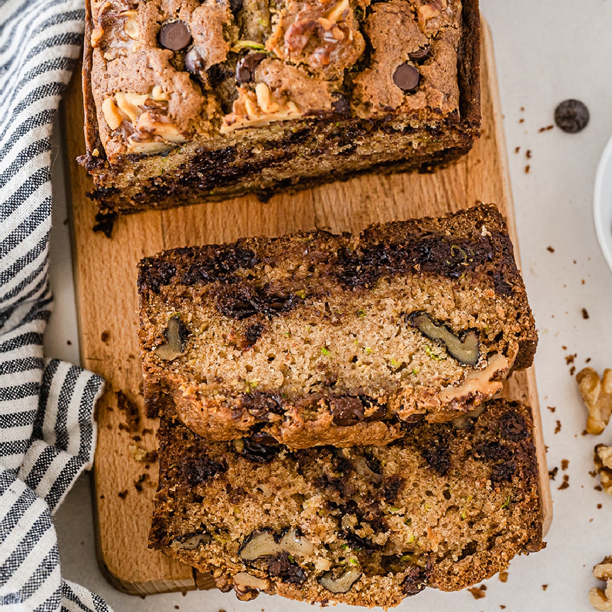 Square view of chocolate chip zucchini bread sliced on a cutting board from overhead.