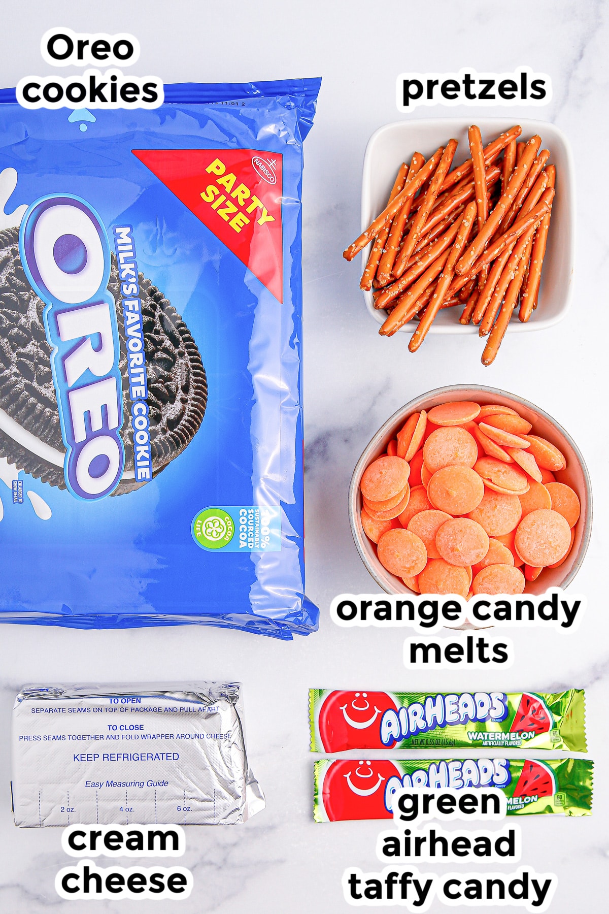 Ingredients for pumpkin Oreo balls on a kitchen counter with text title labels on top.