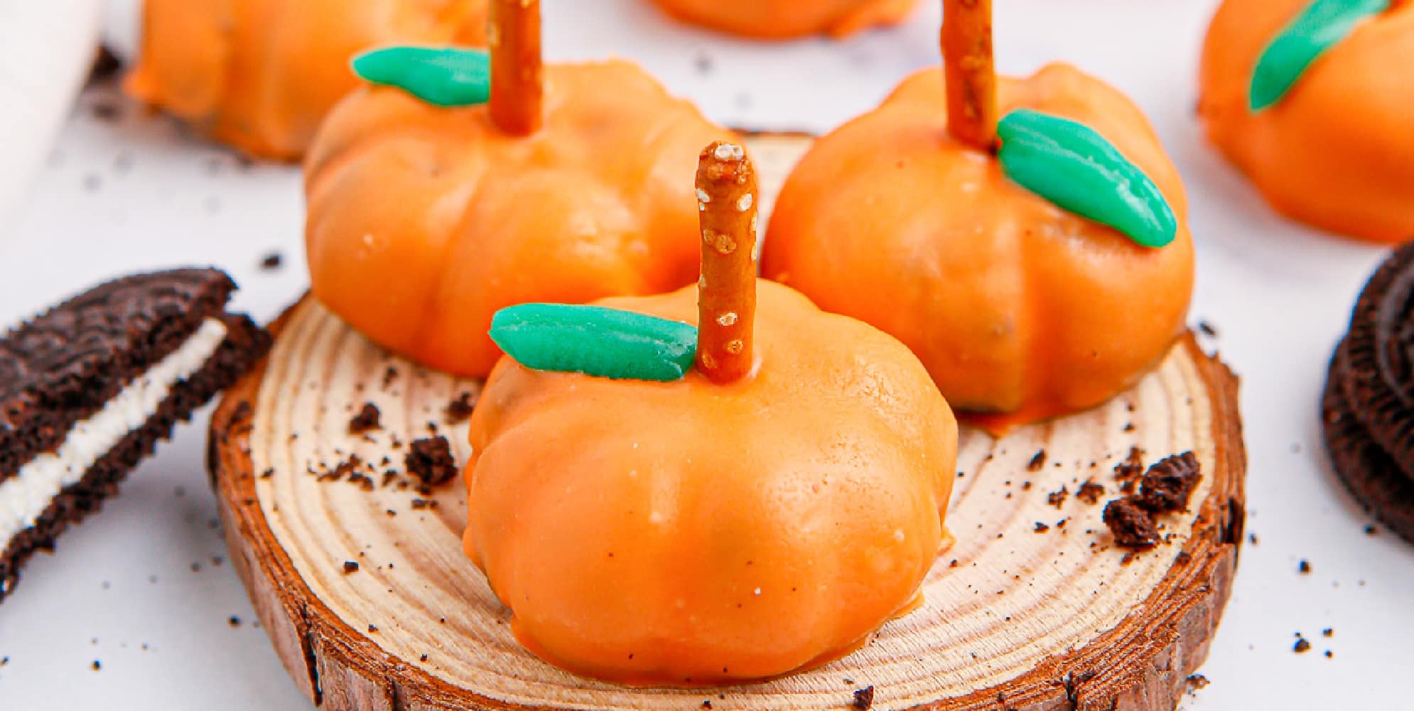 Wide view of pumpkin oreo balls on a platter from the side close up.