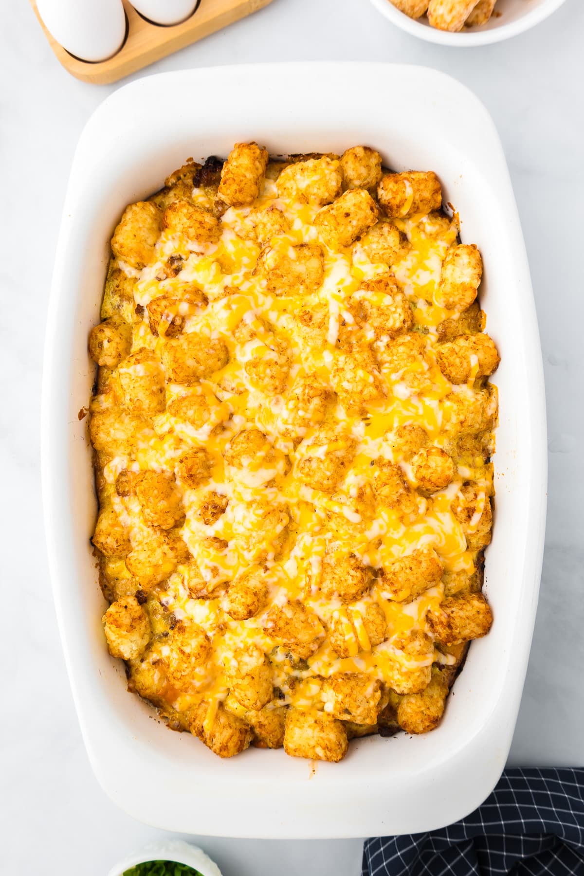 Cheesy tater tot casserole in a white dish after baking.