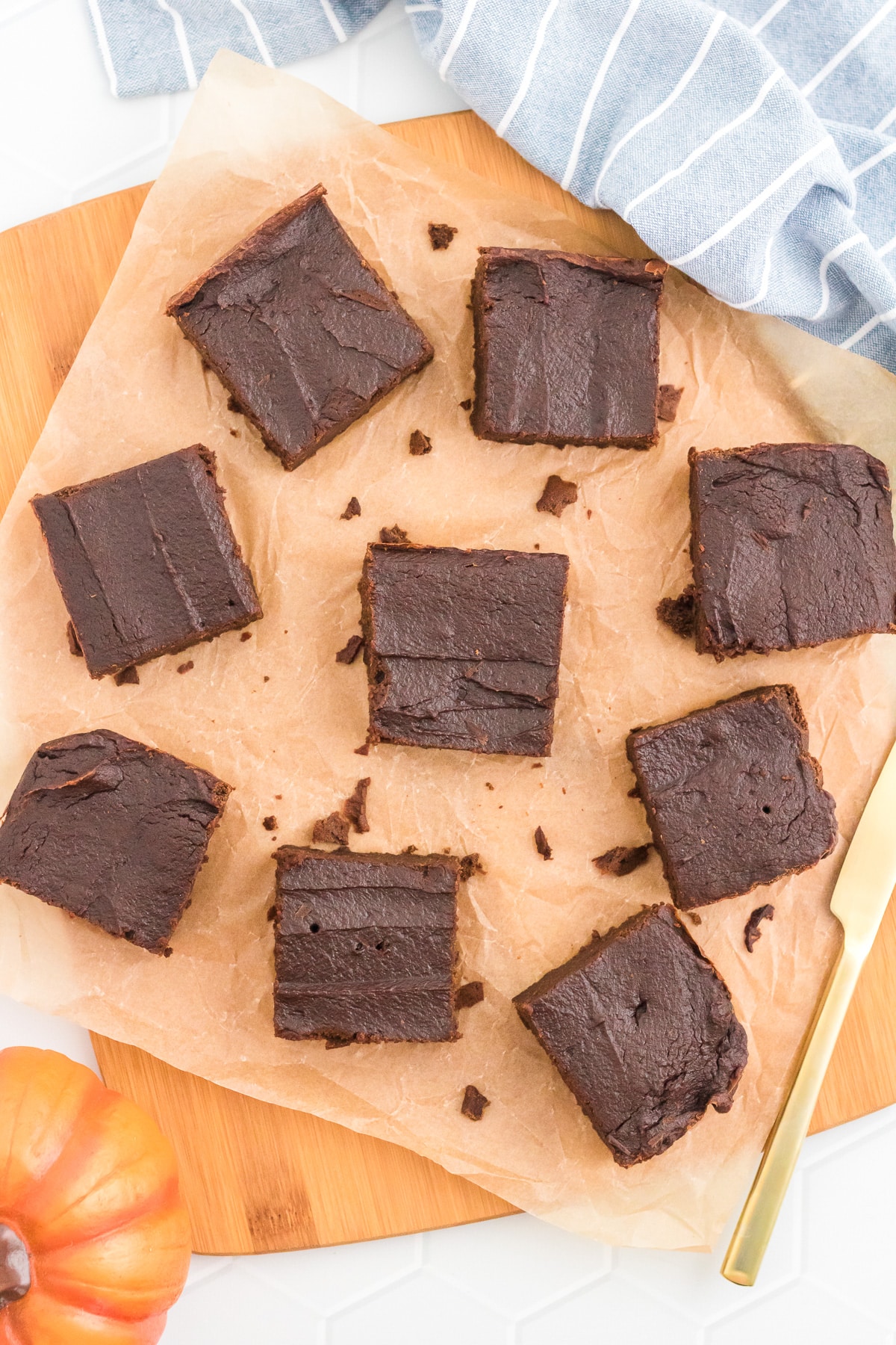 Chocolate pumpkin brownies on a cutting board sliced into squares.