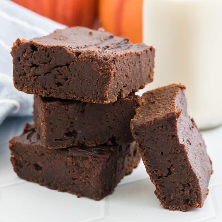 A stack of chocolate brownies on a white plate.