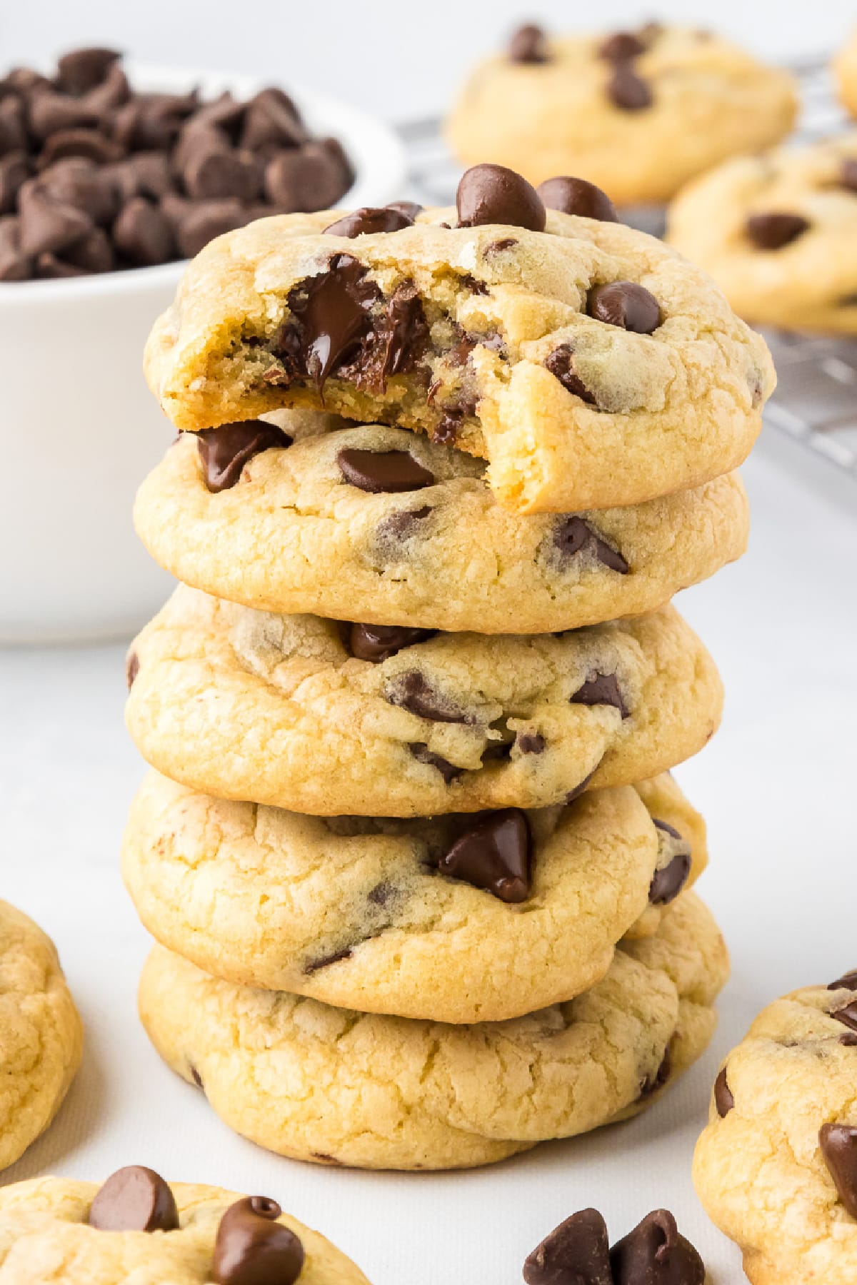 A stack of chocolate chip pudding cookies with the top cookie with a bite taken out.