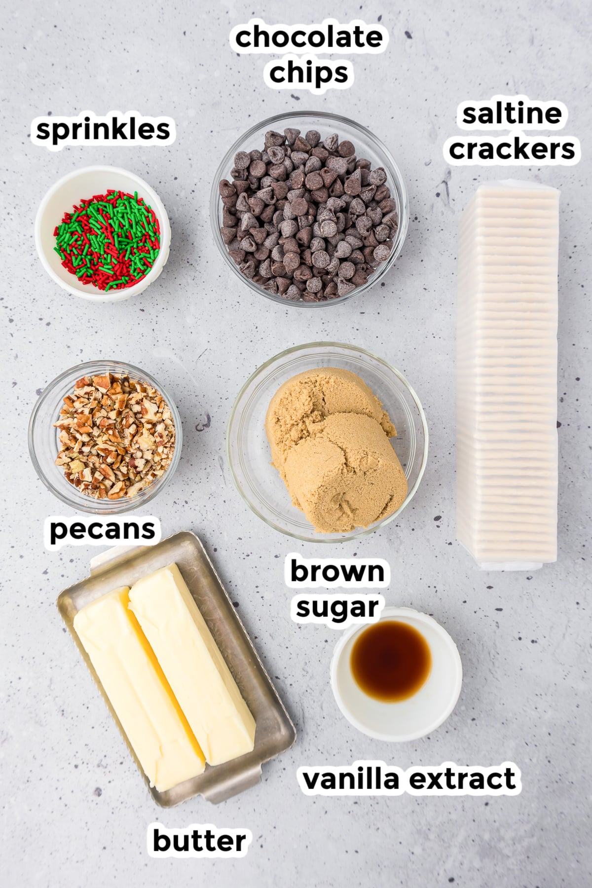 Ingredients for saltine cracker toffee on a counter in bowls with text title labels.