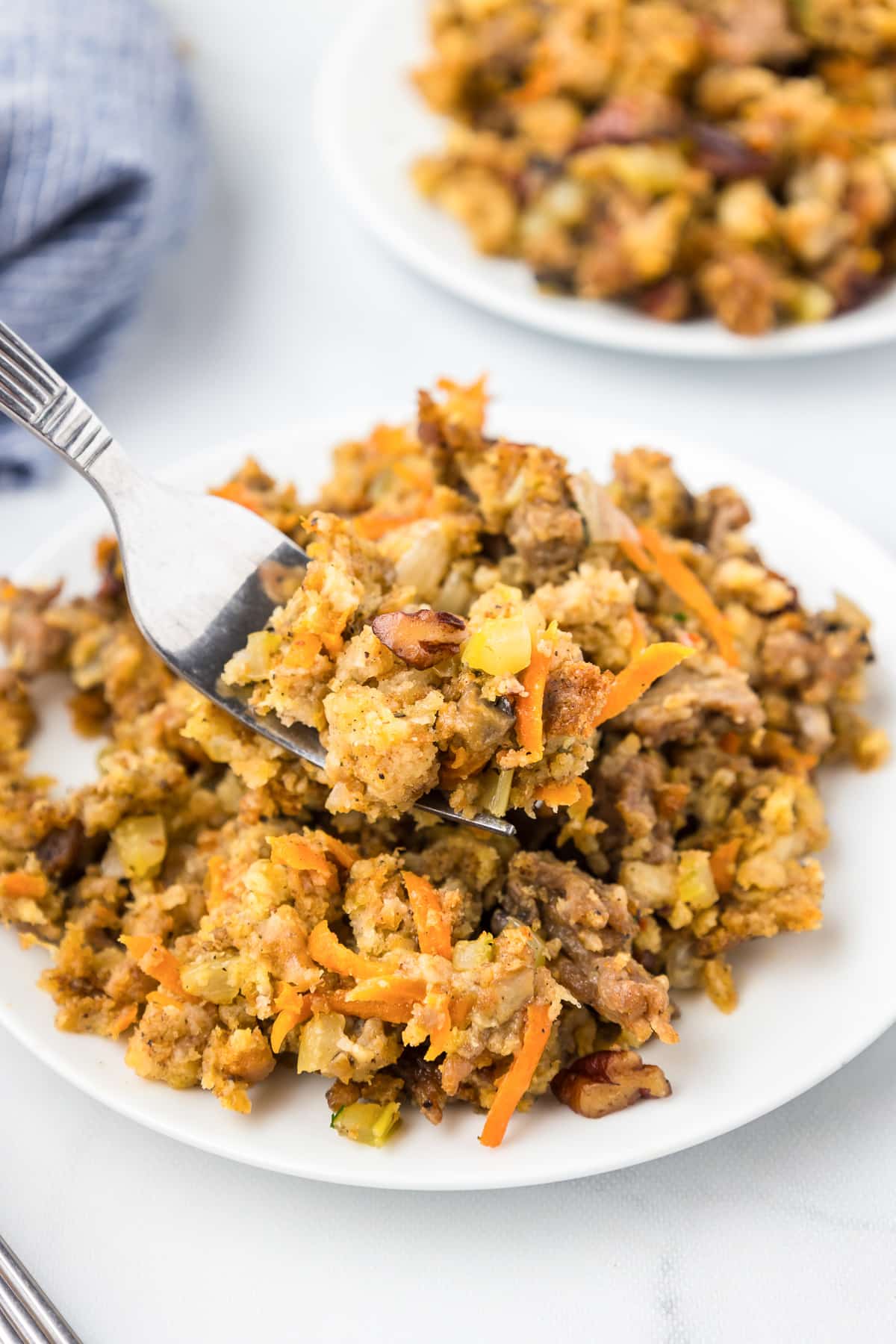 Sausage stuffing on a plate being lifted with a with a fork.