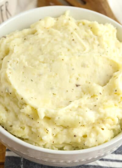 A close up view of a bowl of herb garlic cream mashed potatoes.