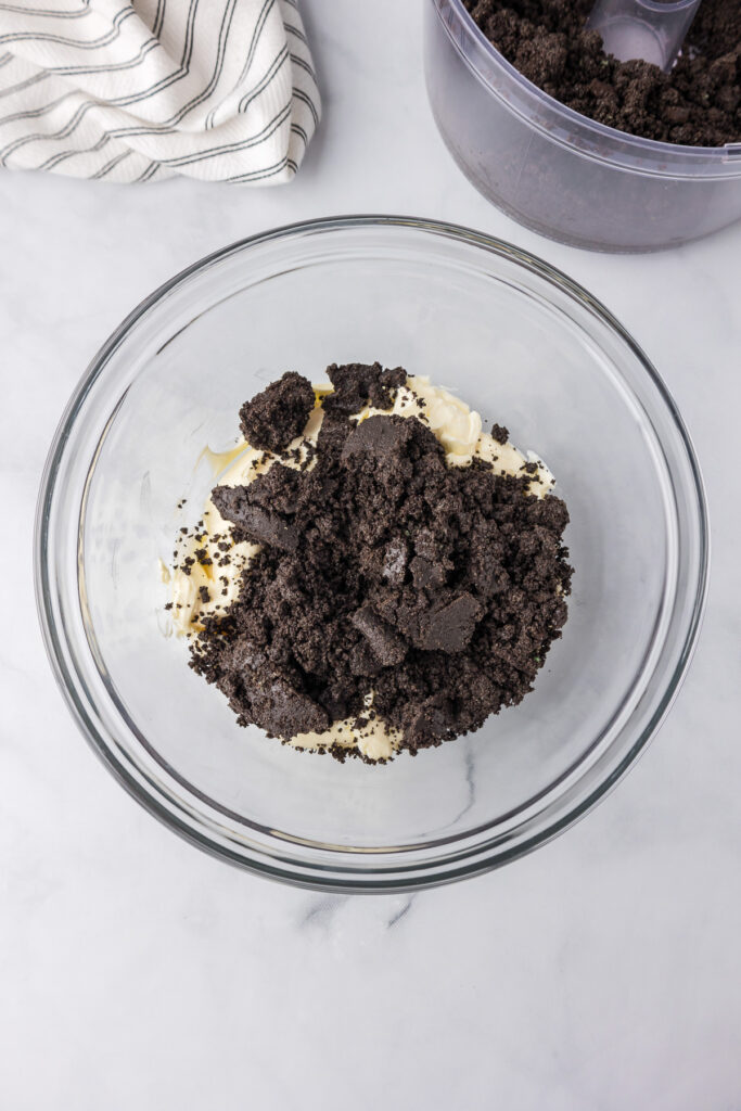 Oreo cookie crumbs and cream cheese in a bowl from above.