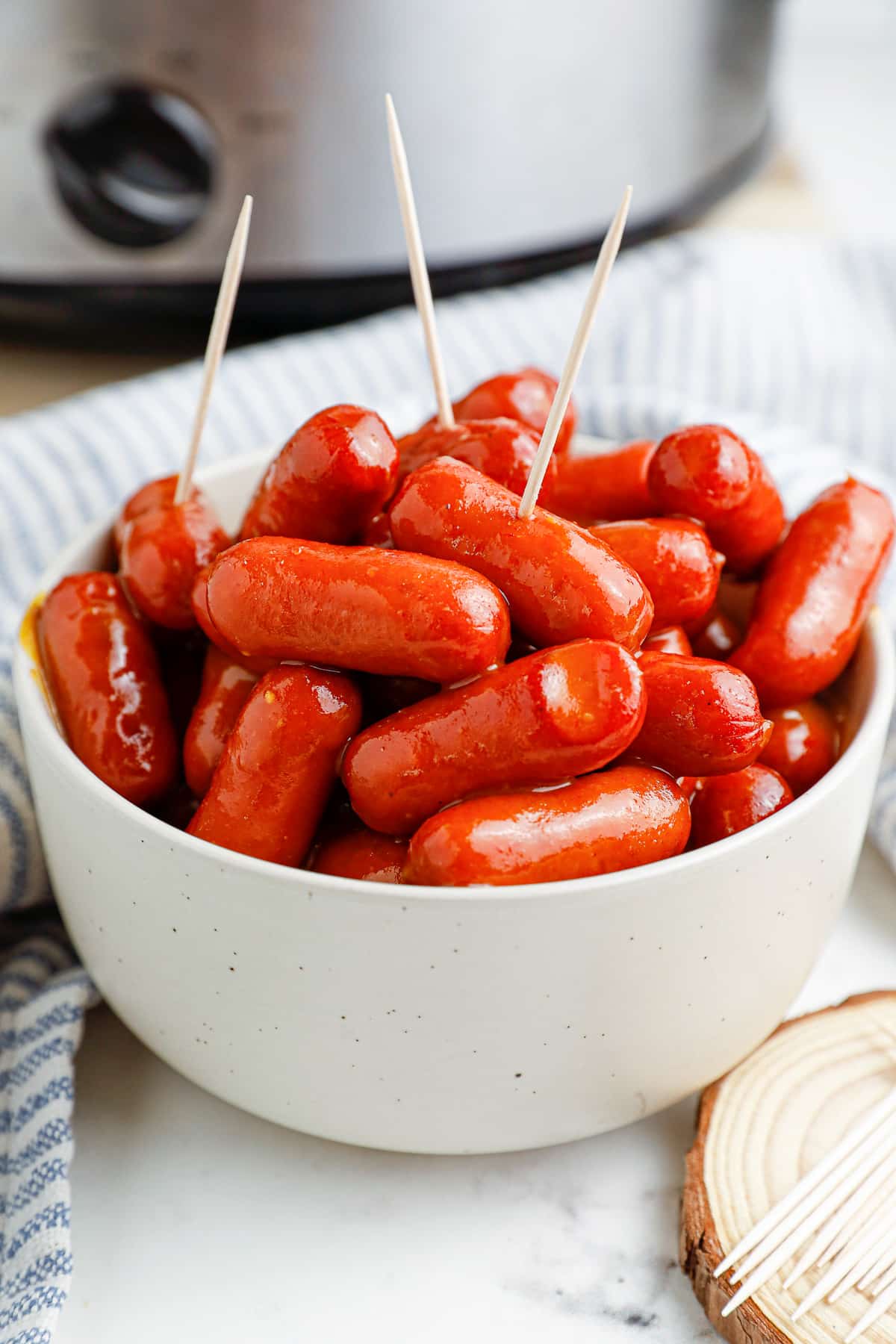BBQ little smokies in a serving bowl with toothpicks in the top sausages.