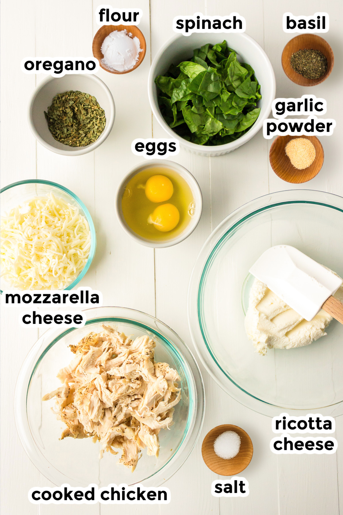 Ingredients for a garlic cheesy chicken calzone in bowls with text labels from above.