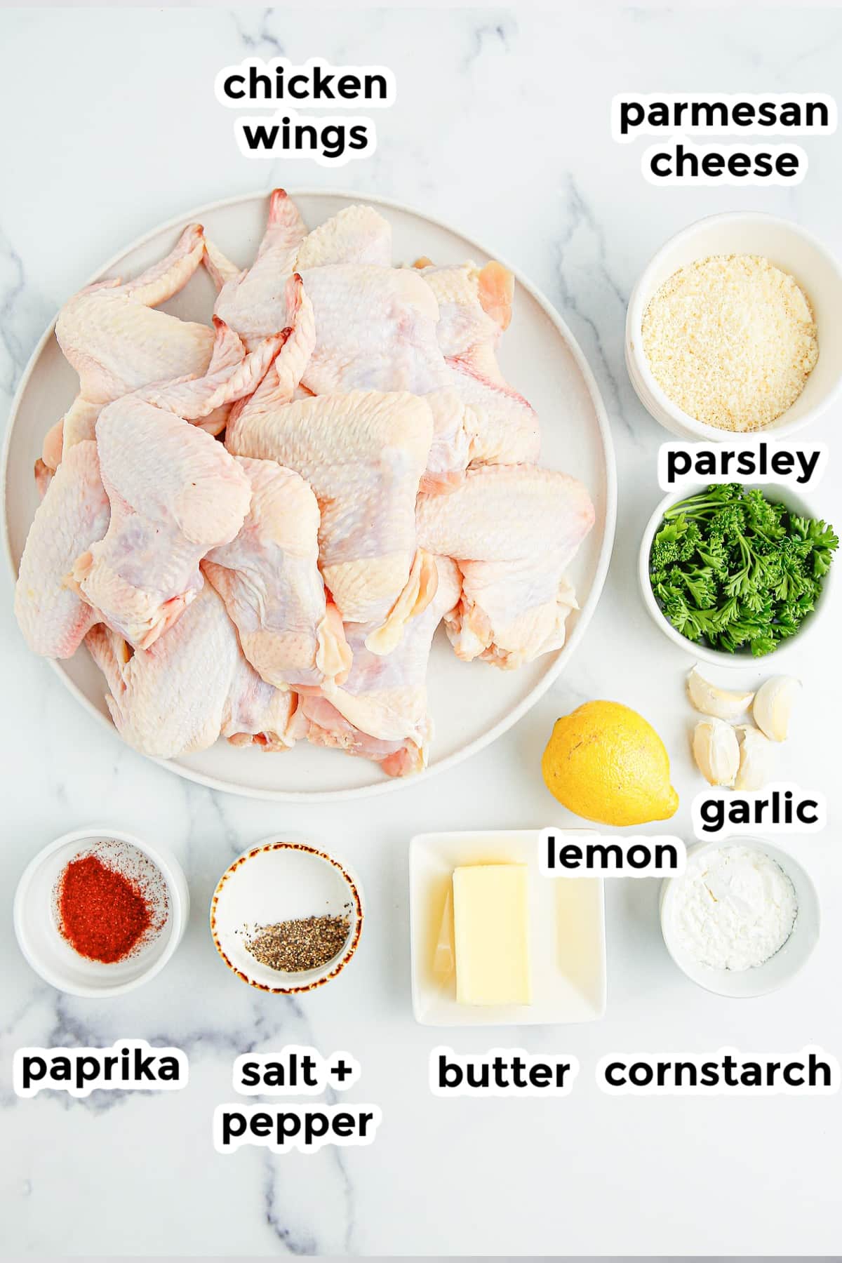 Chicken wings ingredients on a white marble table.