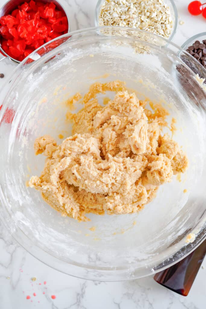 A bowl full of ingredients for peanut butter cookie dough.