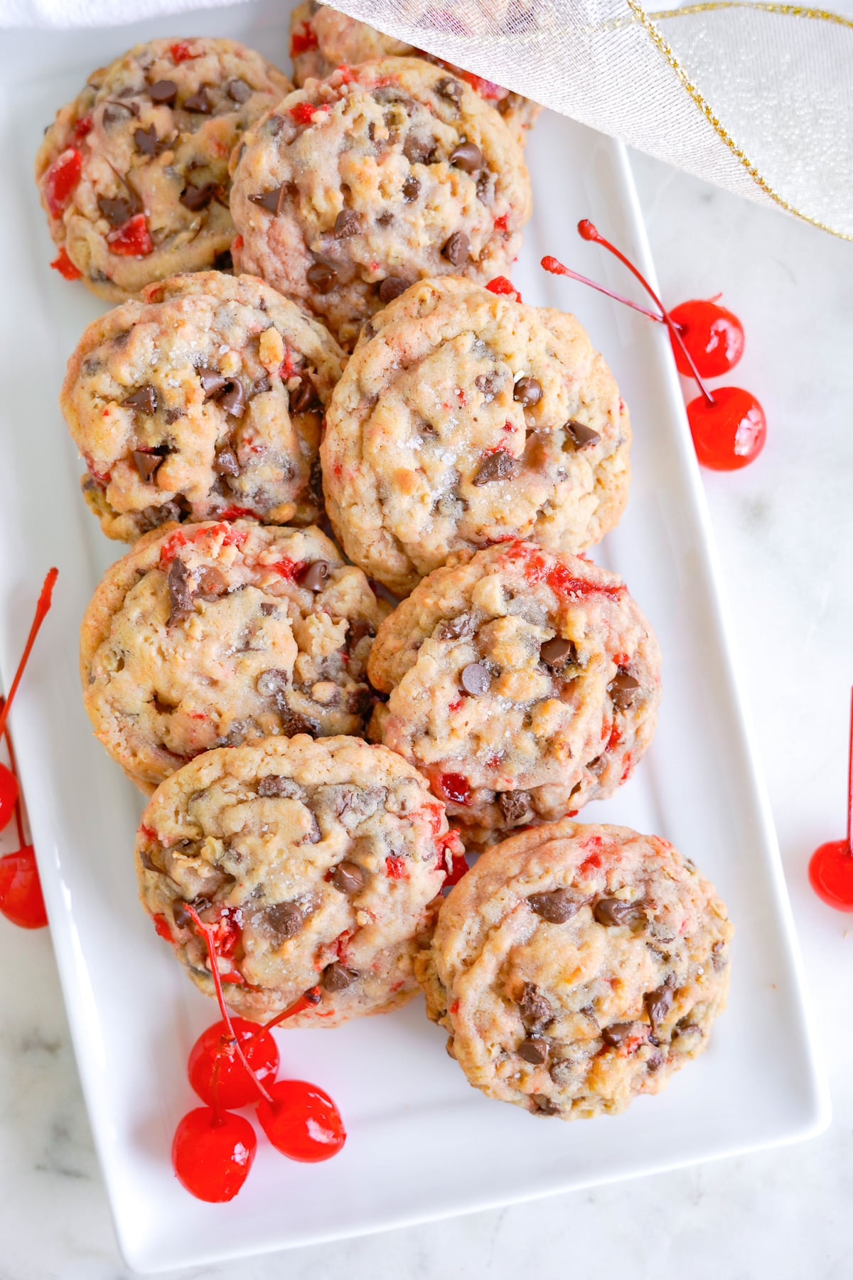 Maraschino cherry cookies with chocolate chips on a white plater.